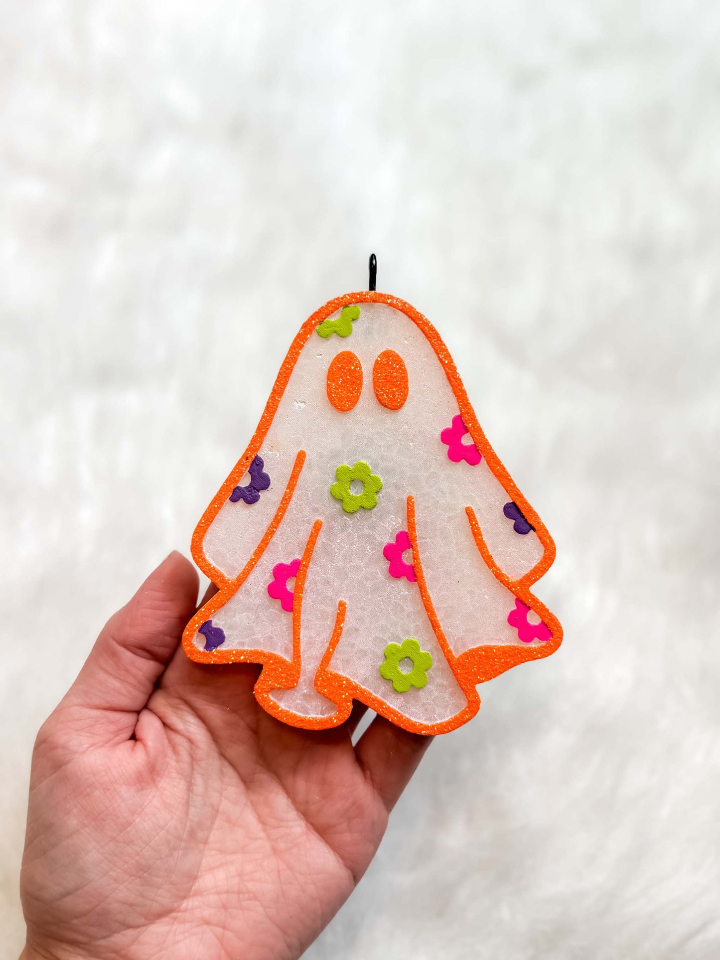 Daisy Ghost Freshie in translucent white acrylic with orange trim, orange face, and colorful daisy embellishments