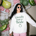 Bride sweatshirt in white cotton with green “Literally Just a Bride” lettering and engagement ring graphic, crew neck and relaxed fit