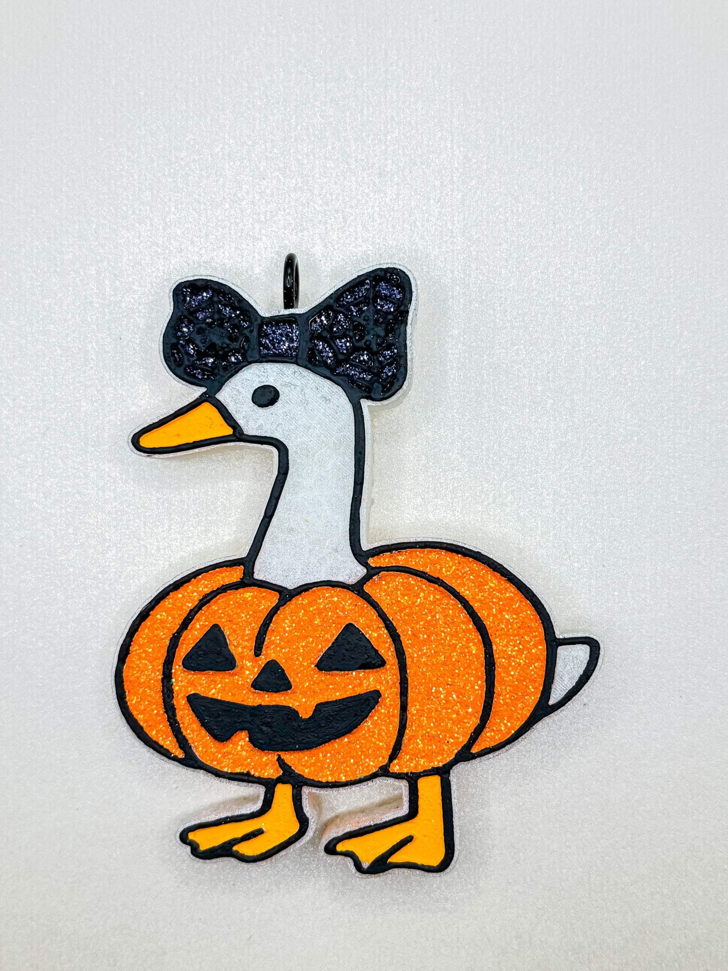 Pumpkin Goose Freshie featuring an orange glitter pumpkin-bodied goose with a black bow and jack-o'-lantern face