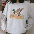 Southern Mama Duck light gray crewneck sweatshirt with a colorful flying mallard graphic and vintage orange lettering