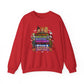 A red crewneck sweatshirt featuring a colorful graphic print on the front with characters and text from 'The Nightmare Before Christmas', including Jack Skellington, and Sally.