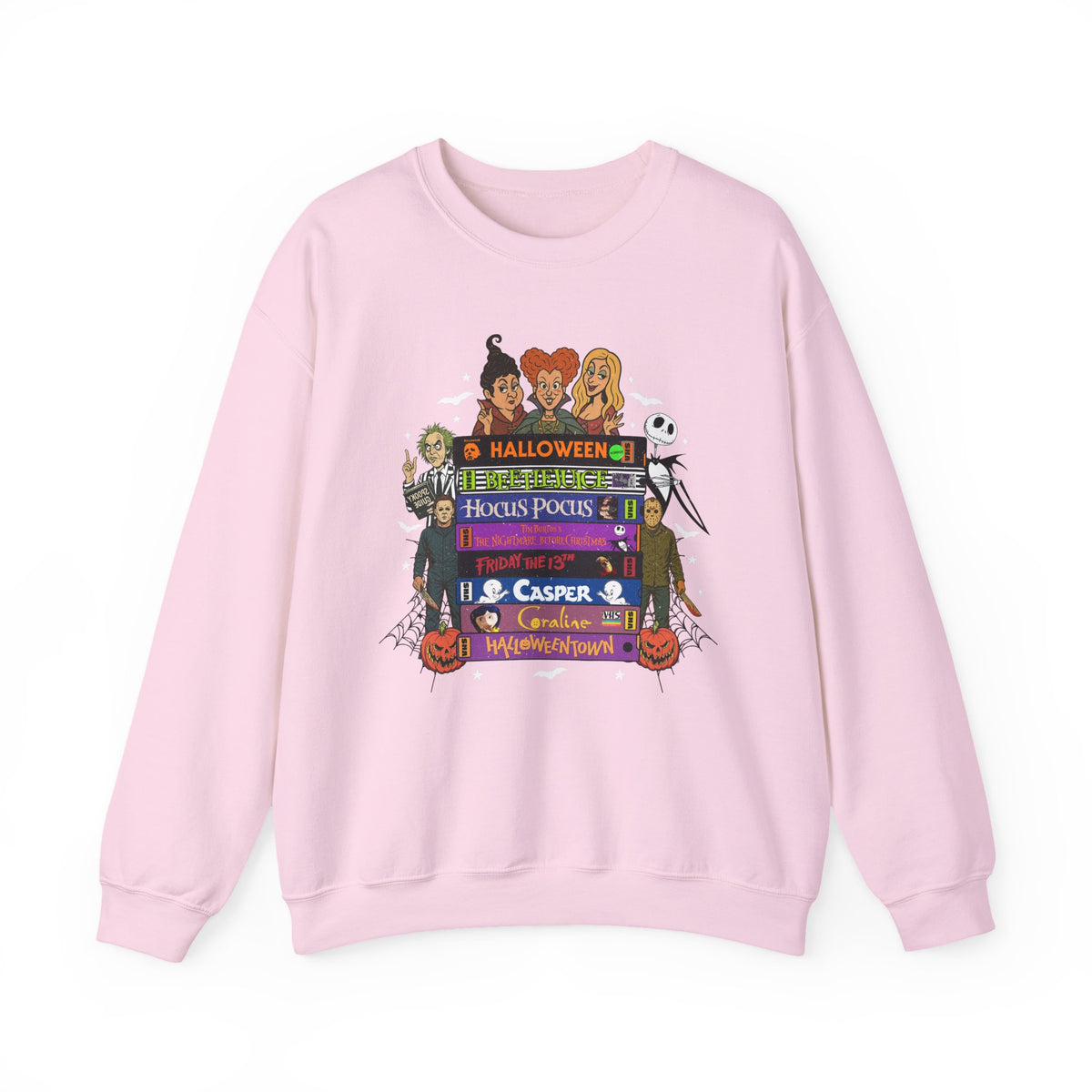 A light pink crewneck sweatshirt featuring a colorful graphic print on the front with cartoon characters and Halloween-themed VHS tapes text including 'Halloween', 'Hocus Pocus', and 'Casper'.