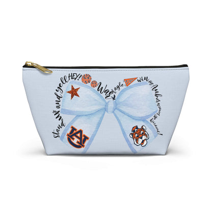 Light-blue Blue Bow Auburn Logo accessory pouch with watercolor bow and collegiate icons, gold zipper pull, and T-bottom structure