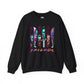 A black crewneck sweatshirt featuring a graphic print of the 'Friends' logo made from colorful tiki knives, with the word 'FRIENDS' written below in a pink-to-purple gradient.