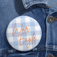 Glossy blue gingham War Eagle Pin Button with steel safety-pin back on denim jacket lapel