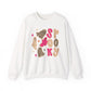 An white crewneck sweatshirt featuring a 'Spooky' Halloween graphic with pink ghosts, leopard print ghosts, and stars on the front.