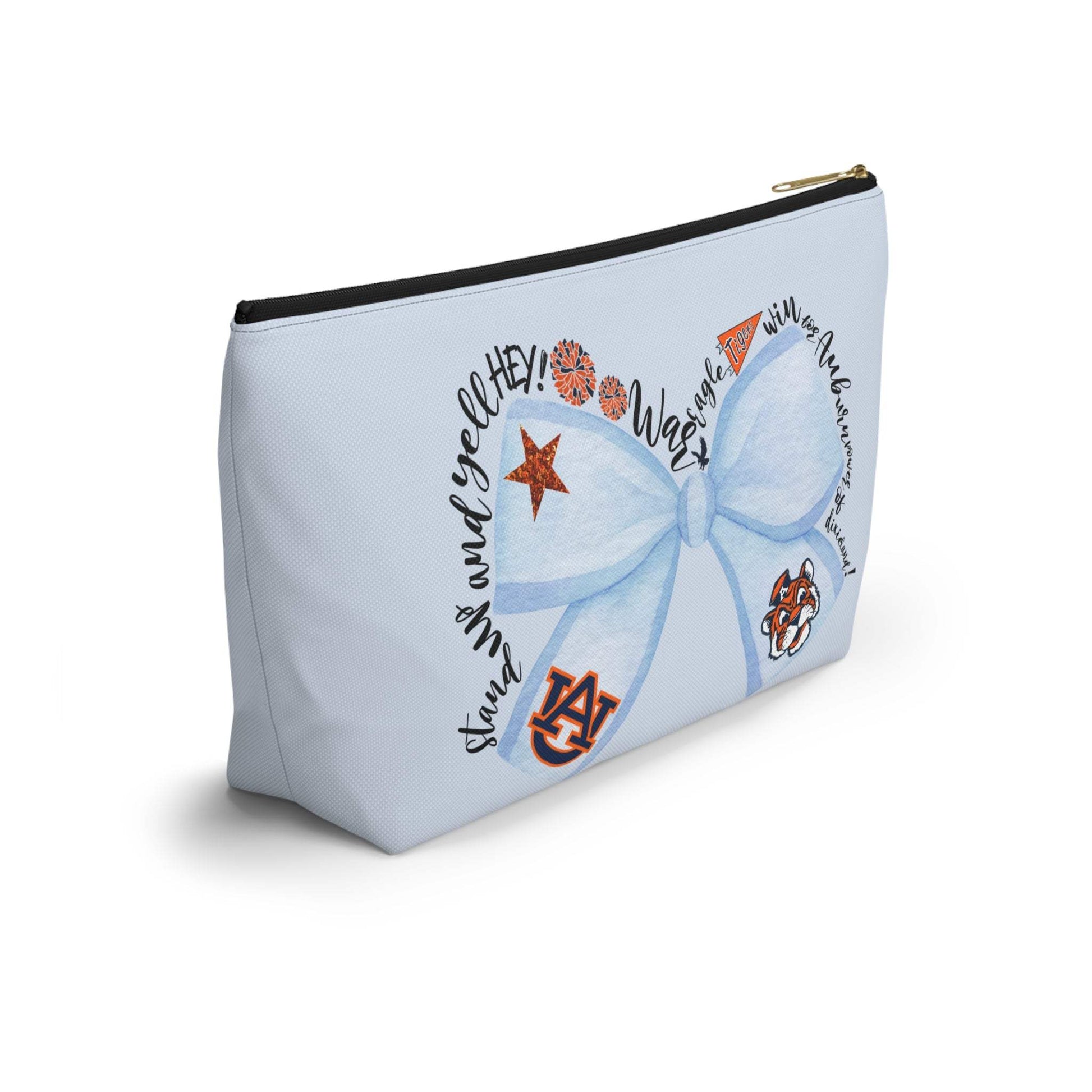 Light-blue T-bottom accessory pouch with watercolor blue bow, Auburn logo, and collegiate icons, gold zipper pull, wrinkle-resistant polyester