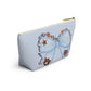 Light-blue T-bottom cosmetic pouch featuring a watercolor blue bow and Auburn logo with collegiate icons and gold zipper pull