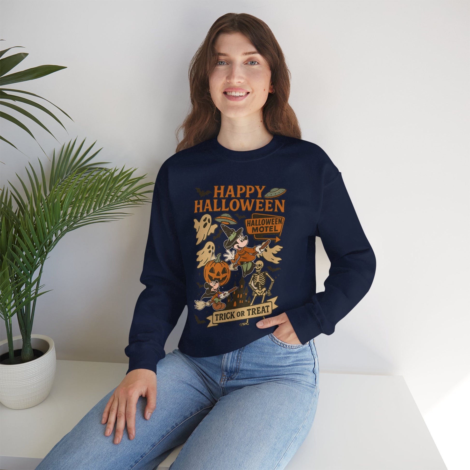 Woman wearing a navy blue sweatshirt with a floral design sitting on a white surface.