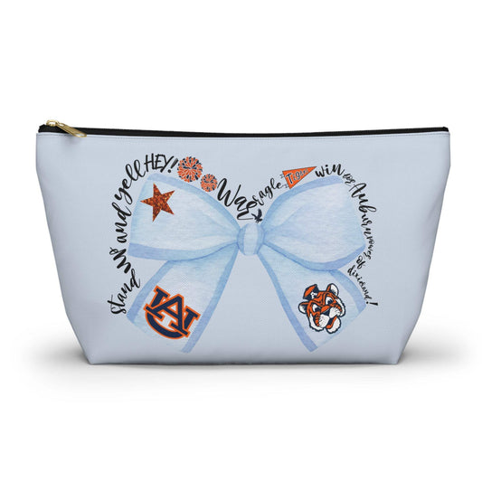 Light blue T-bottom pouch with blue bow Auburn logo and collegiate icons, gold zipper pull, wrinkle-resistant polyester cosmetic bag