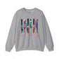 A heather gray crewneck sweatshirt featuring a graphic of six knives with colorful tie-dye patterns and the word 'FRIENDS' printed below in the iconic yellow font, shown against a plain white background.