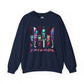 A navy crewneck sweatshirt featuring a graphic print of the 'Friends' logo made from colorful tiki knives, with the word 'FRIENDS' written below in a pink-to-purple gradient.