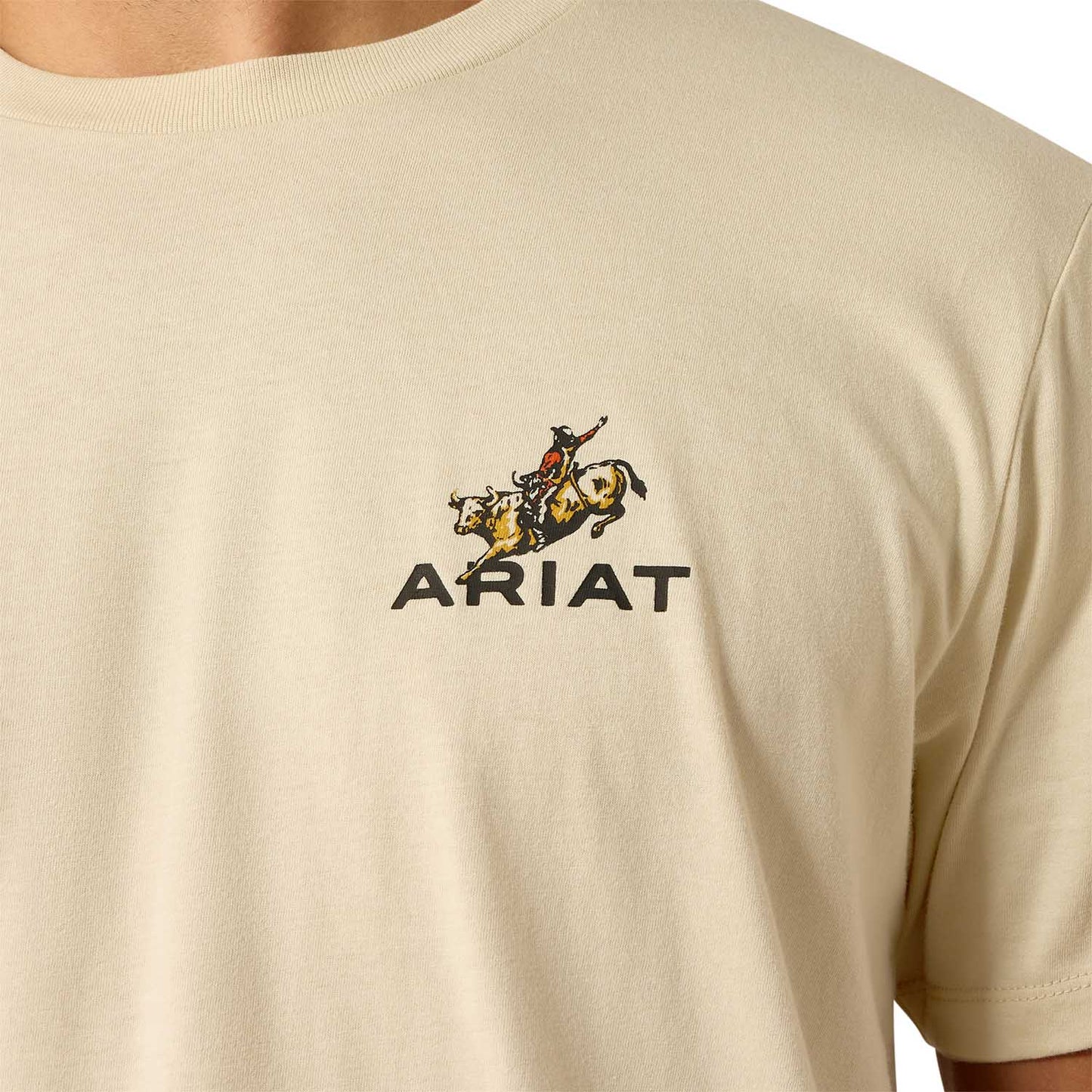 Ariat Mens Short Sleeve Shirt in beige cotton with a small rodeo rider graphic and black ARIAT text on the chest.