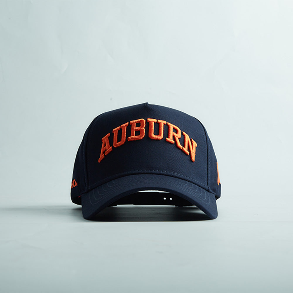 Navy blue snapback cap with bold orange 3D "AUBURN" embroidery, curved bill, and Auburn Alabama Legacy design.