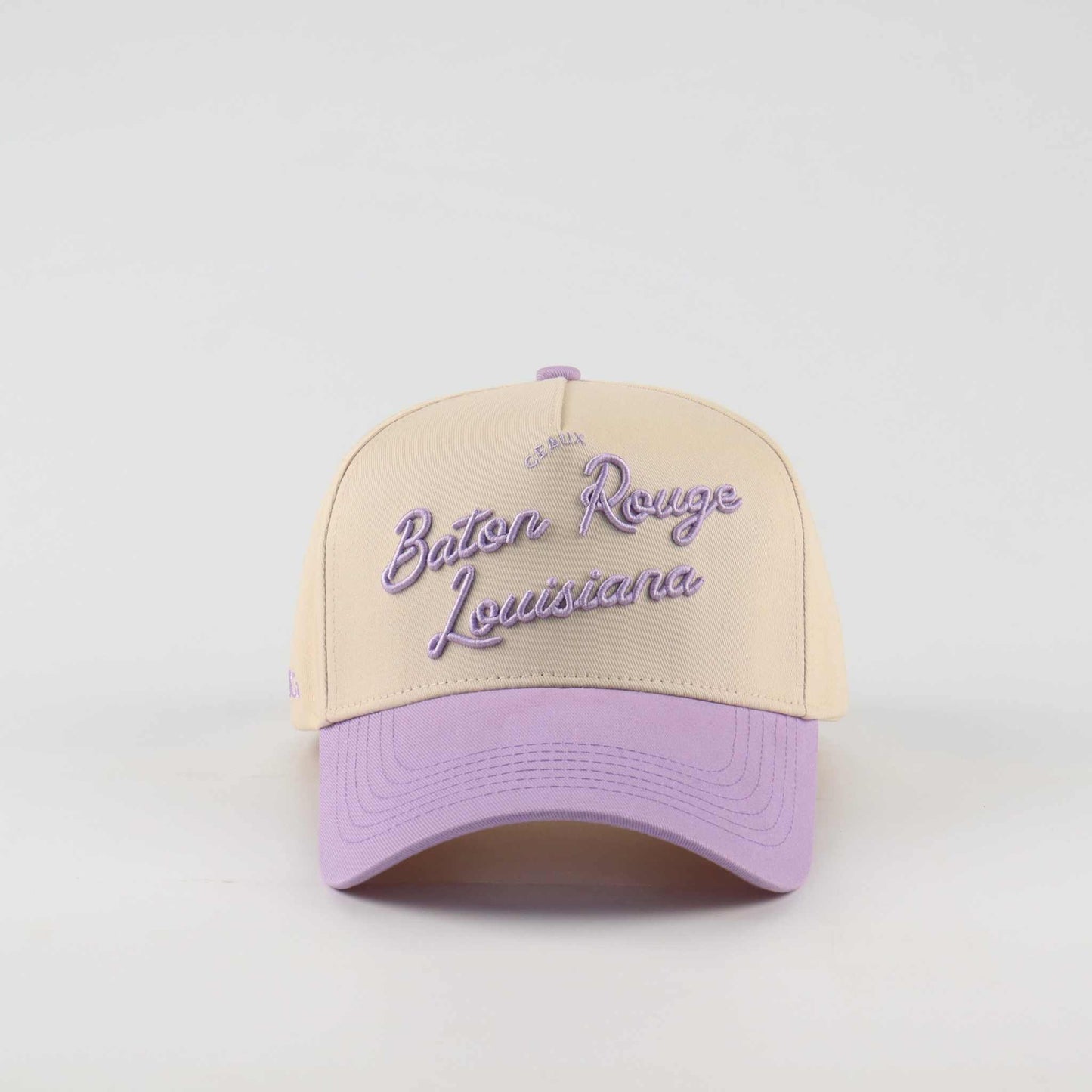 Trucker hat in beige and lavender with purple Baton Rouge Louisiana script and a pre-curved brim, Callin’ Baton Rouge!