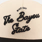 Bayou Script Hat in beige with black embroidered Bayou State script and Who Dat lettering