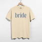 Bride Est. 2026 tee in cream cotton with blue serif bride lettering and pink 2026 detail