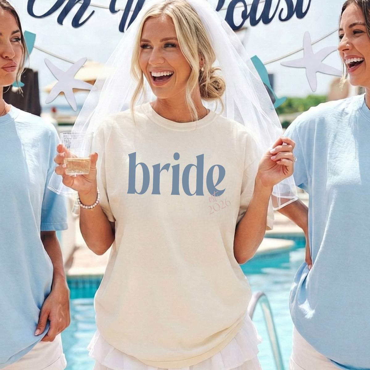 Bride Est. 2026 ivory cotton t-shirt with blue serif bride lettering and pink embroidered-style date detail