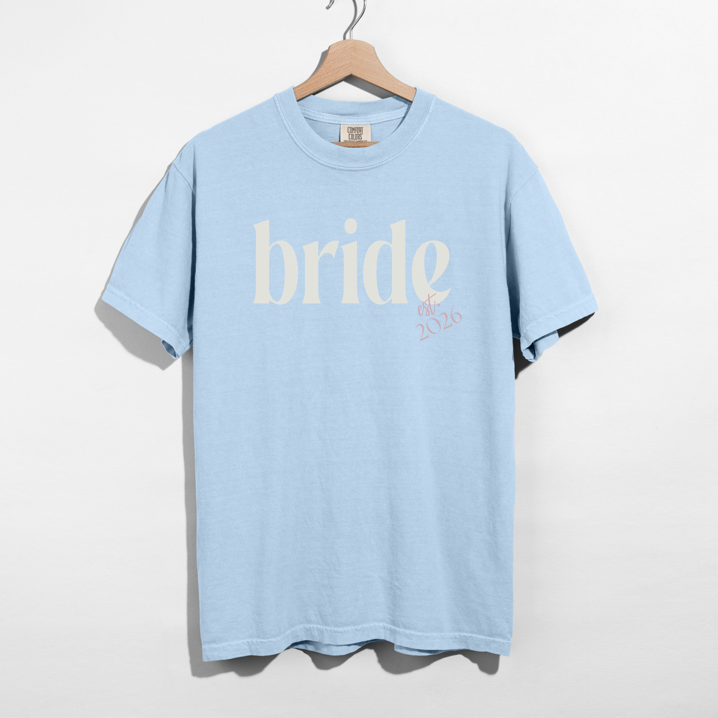 Bride Est. 2026 t-shirt in light blue cotton with white serif bride lettering and pink embroidered-style year detail