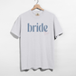 Bride Est. 2026 tee in white cotton with blue serif bride lettering and pink Est. 2026 detail