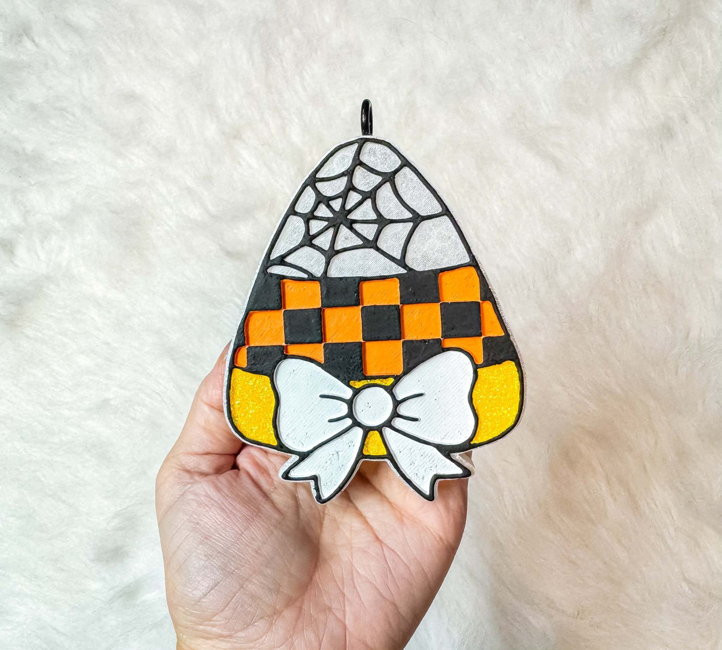 Candy Corn Freshie with orange and black checkerboard pattern, spiderweb detail, and white bow