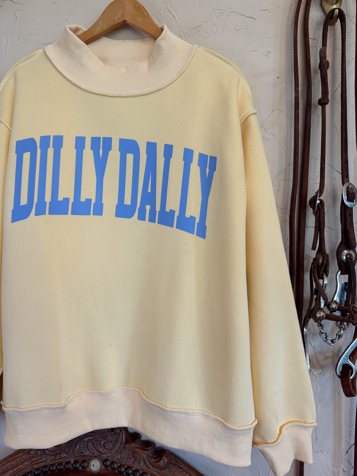Dillydally Mock Neck Sweatshirt in butter yellow with baby blue "DILLY DALLY" graphic, soft cotton blend fabric.