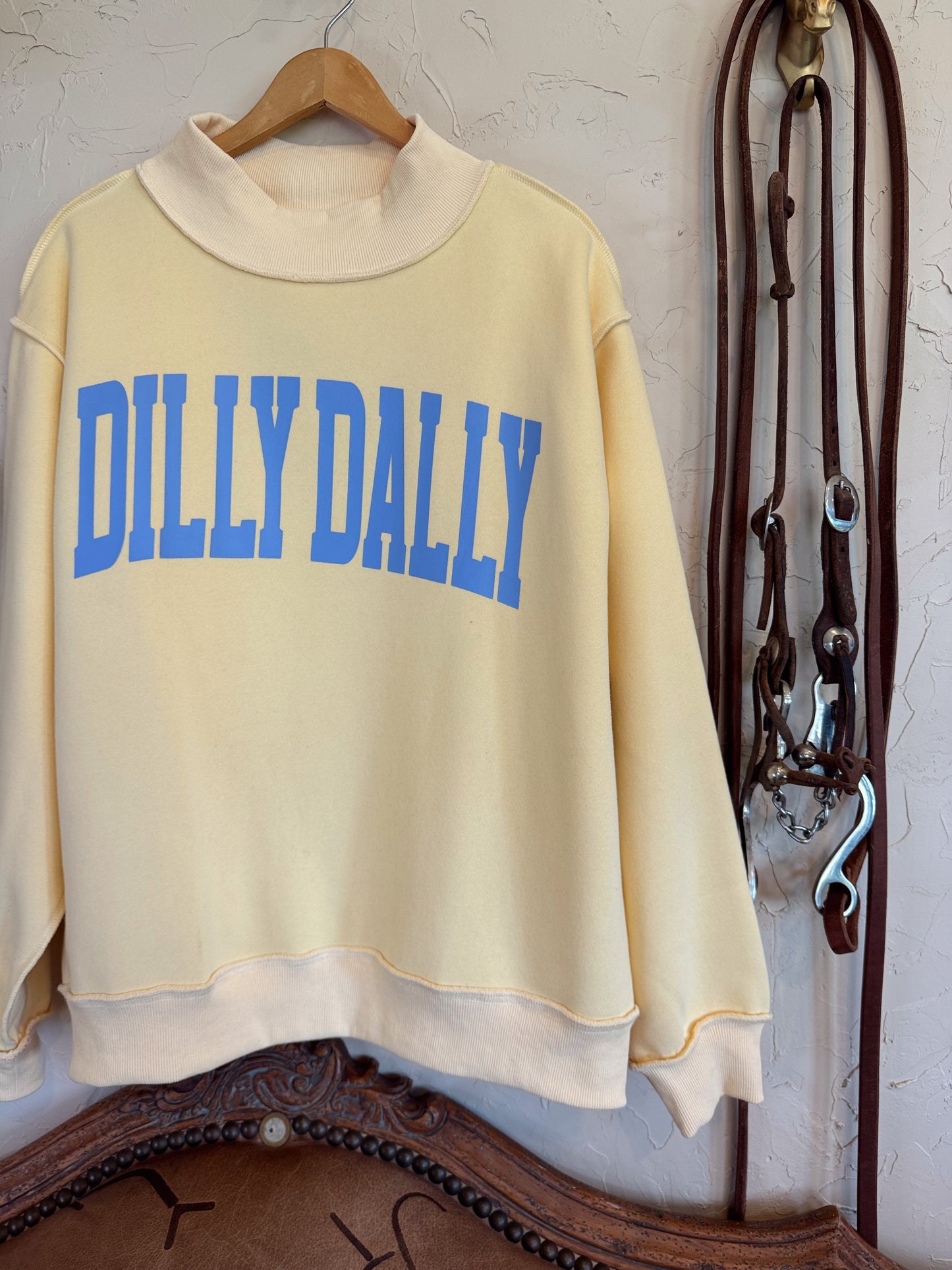 Dillydally Mock Neck Sweatshirt in soft butter yellow cotton blend with baby blue "DILLYDALLY" graphic and cozy fit.