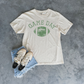 Football Graphic Tee in ivory cotton with green distressed Game Day lettering and football graphic