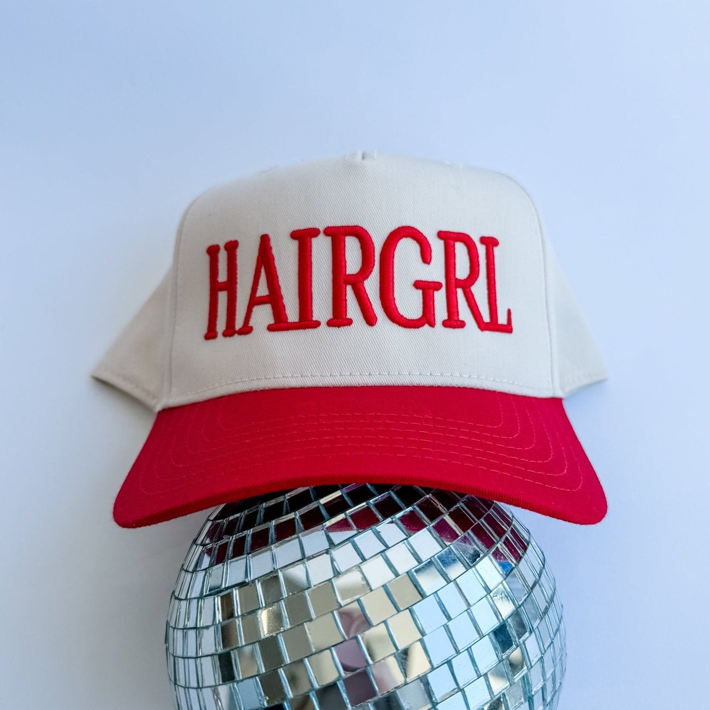 HAIRGRL - Trucker Hat with cream front, red bill, and raised red 3D puff embroidery on adjustable snapback closure