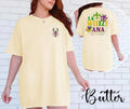 Woman wearing a yellow t-shirt with a crawfish design and text, standing against a white brick wall.