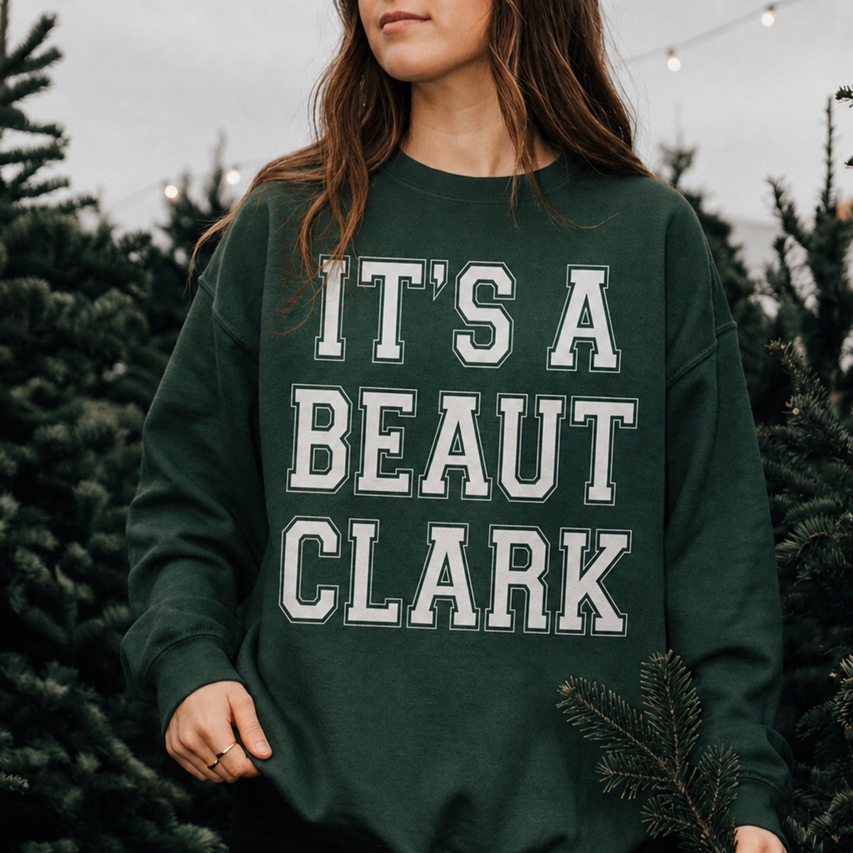 It's a Beaut Clark Christmas Sweatshirt in forest green with bold white collegiate lettering and a crewneck design
