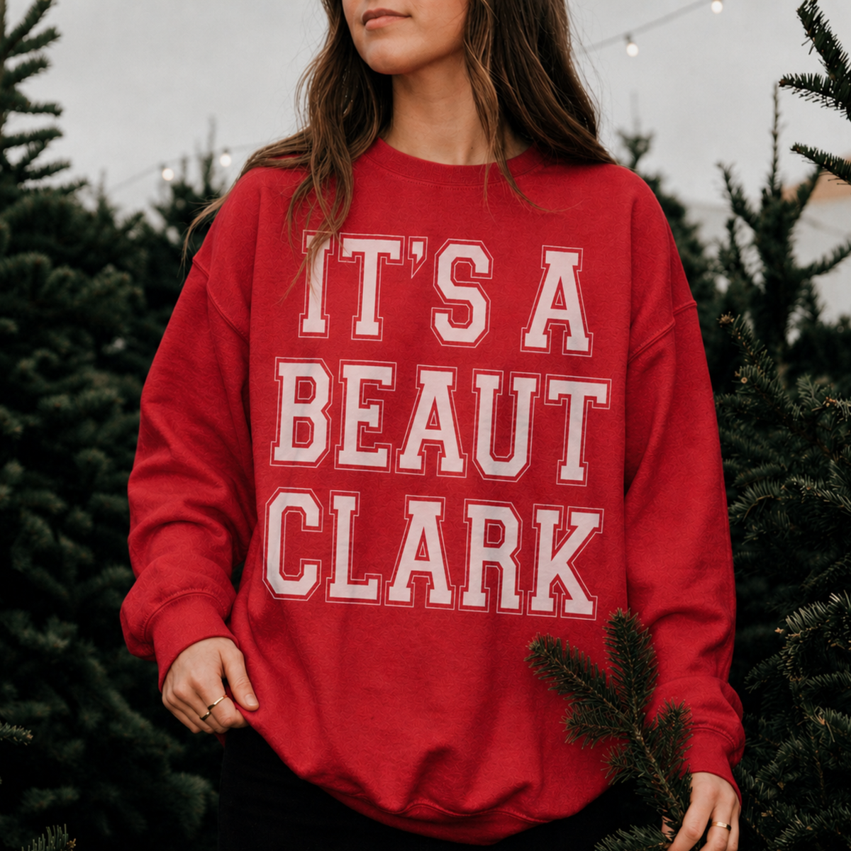 It's a Beaut Clark Christmas Sweatshirt in red fleece with oversized white collegiate-style lettering and ribbed cuffs