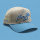 Mom-Ville Script Hat in beige and light blue, featuring embroidered script and a pre-curved brim