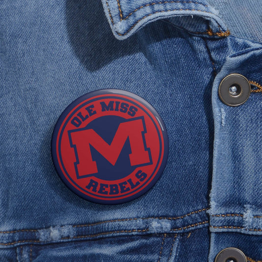 Ole Miss Rebels M Logo Pin in red and navy blue on a metal pin button attached to blue denim fabric