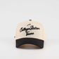 Pre-curved Trucker hat in beige and black with College Station Texas script lettering and curved brim