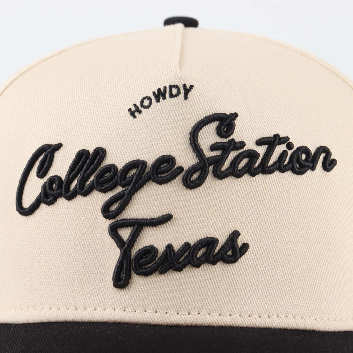 Pre-curved Trucker hat in beige with black embroidered College Station Texas script and Howdy detail