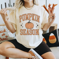Pumpkin Season Graphic Tee in cream cotton, featuring distressed orange lettering and a vintage pumpkin graphic with stars