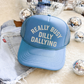 Really Busy Dilly Dallying Trucker Hat in blue foam with curved brim and bold cream statement lettering