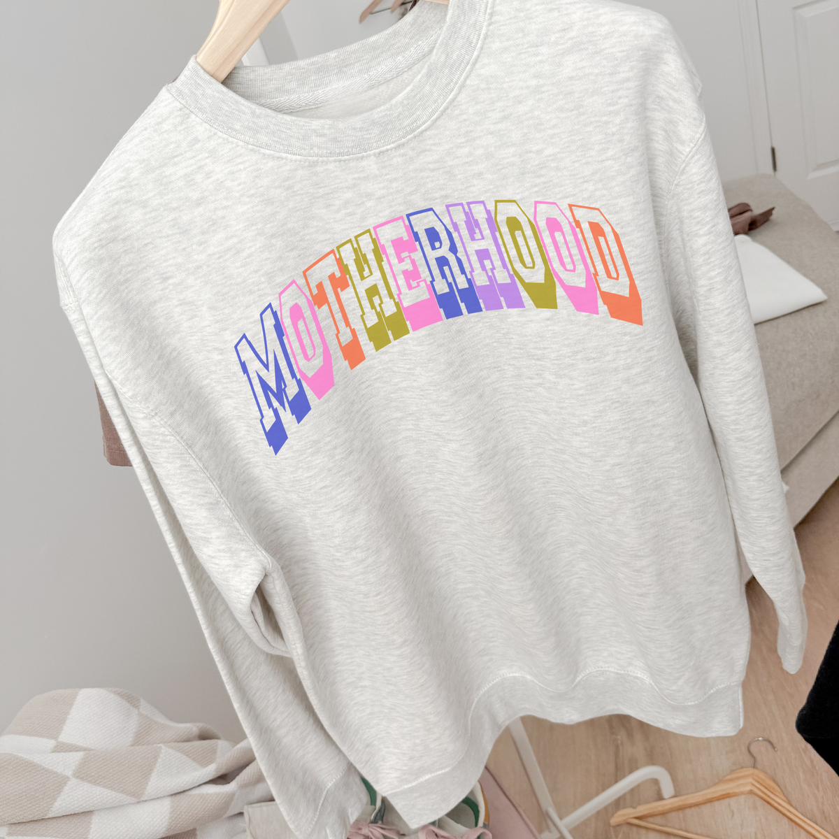 Retro Motherhood Sweatshirt in light grey with colorful retro collegiate lettering and a relaxed crewneck design