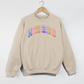 Retro Motherhood Sweatshirt in sand fleece with colorful arched collegiate lettering and ribbed crewneck cuffs