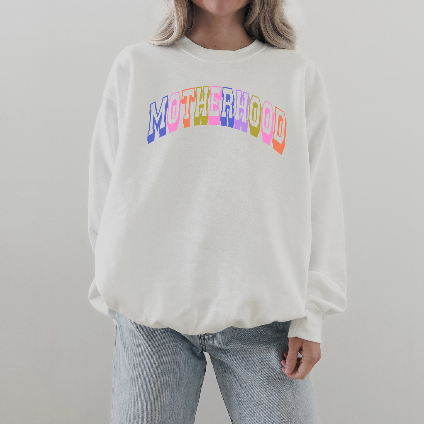 Retro Motherhood Sweatshirt in white with colorful pastel collegiate lettering and a relaxed crewneck fit