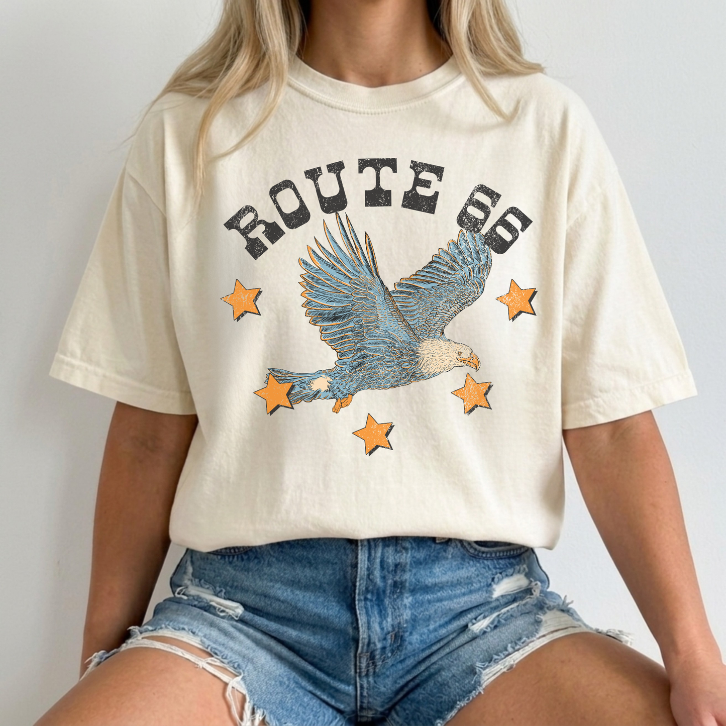Graphic tee in ivory cotton with a distressed Route 66 eagle graphic, blue soaring eagle and orange stars