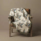 Rustic Cabin Throw featuring a cream cotton woven blanket with flying mallard duck pattern and colorful fringed edges draped over a wooden chair