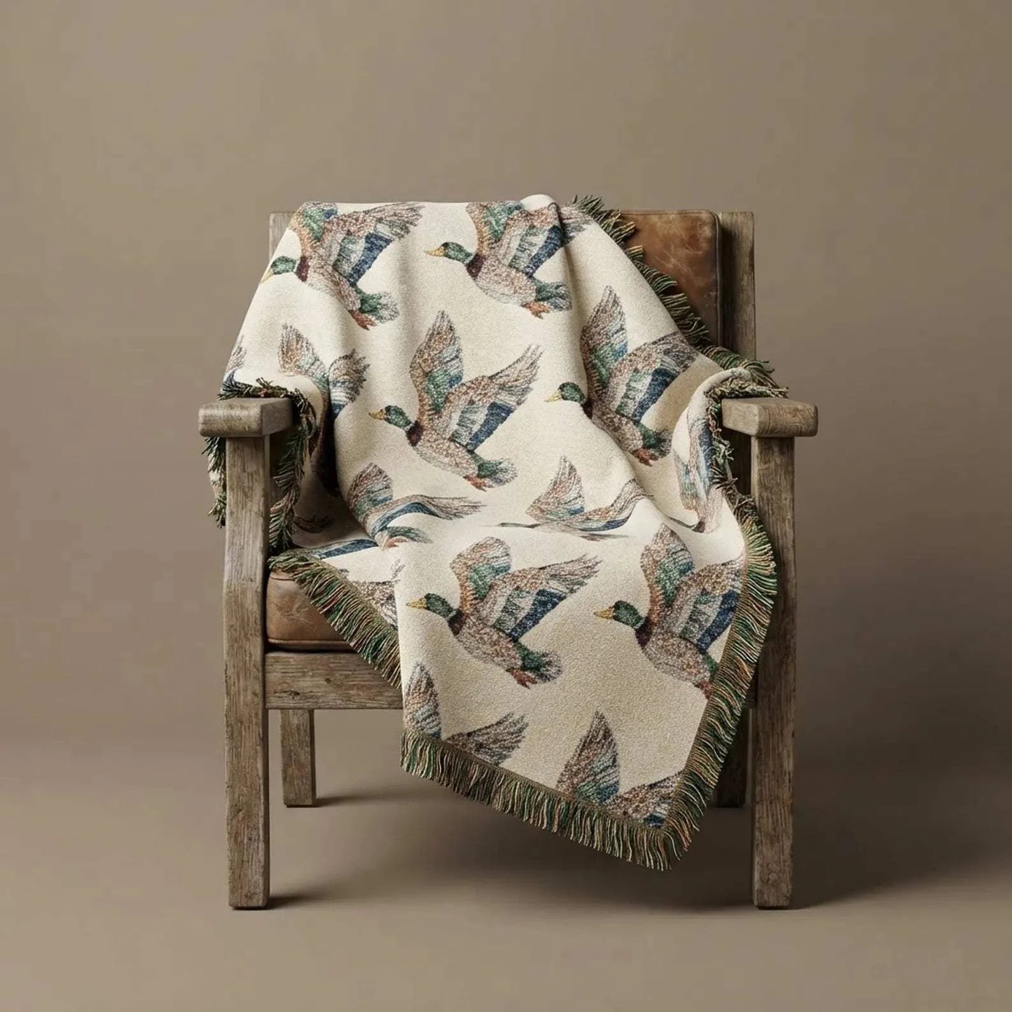 Rustic Cabin Throw featuring a cream cotton woven blanket with flying mallard duck pattern and colorful fringed edges draped over a wooden chair