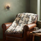 Rustic Cabin Throw featuring a woven Flying Mallard Duck pattern in earthy tones with colorful fringed edges draped over a brown leather chair
