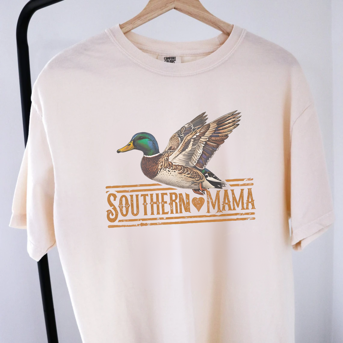 Southern Mama Duck T Shirt in cream cotton with a flying mallard duck graphic and distressed rust lettering