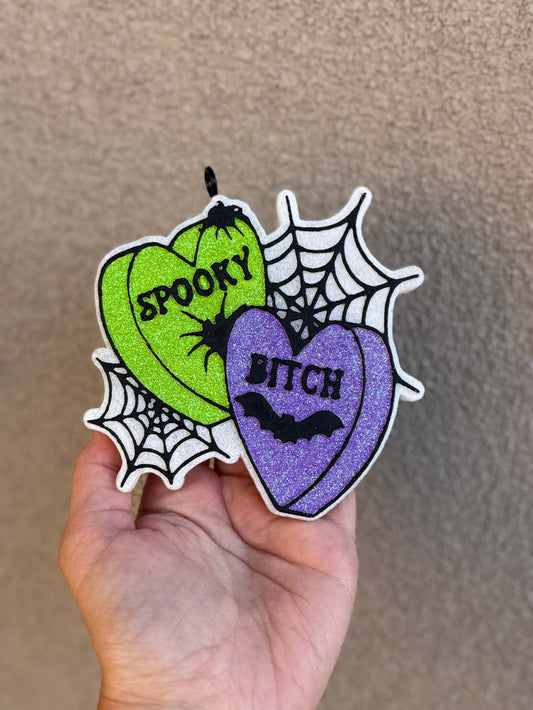 Spooky B Freshie air freshener with glittery green and purple heart designs, spiderweb accents and black lettering