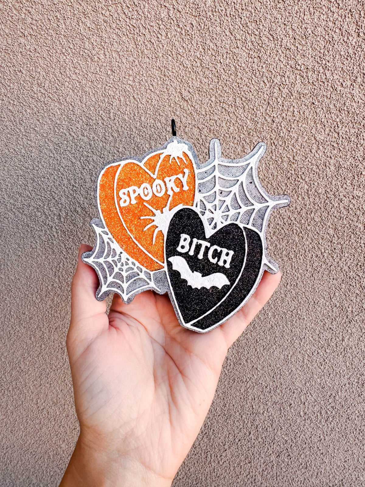 Spooky B Freshie in orange and black glitter hearts with white lettering, spiderweb accents, and bat detail