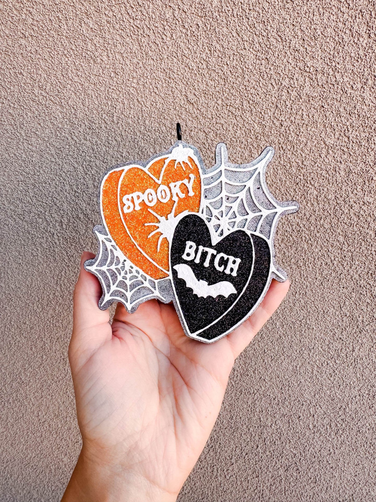Spooky B Freshie in orange and black glitter hearts with white lettering, spiderweb accents, and bat detail