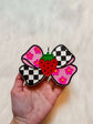 Strawberry Bow Freshie with pink and black checkerboard wings, pink floral pattern, and a red strawberry center